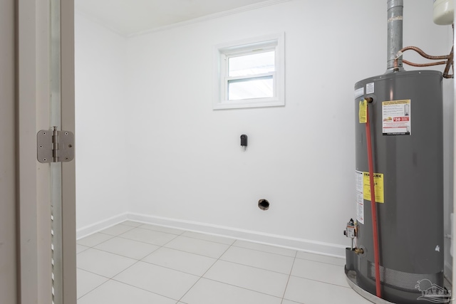 laundry room featuring crown molding, light tile patterned floors, and gas water heater