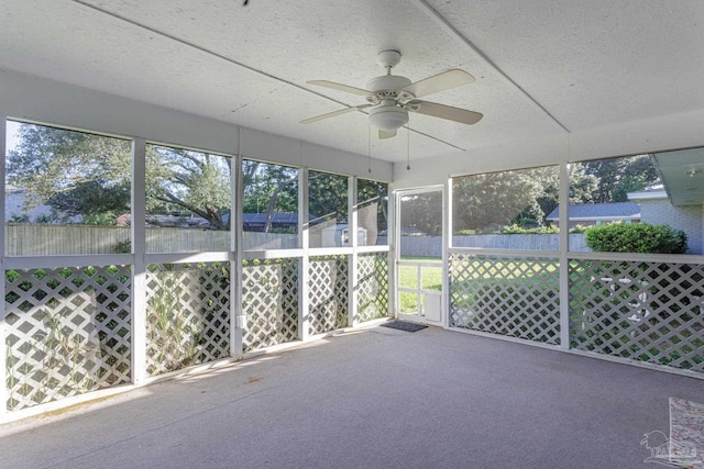 unfurnished sunroom with ceiling fan