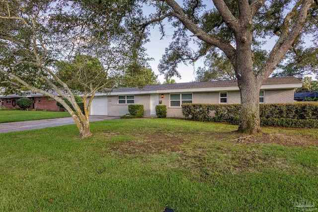 ranch-style home with a garage and a front lawn