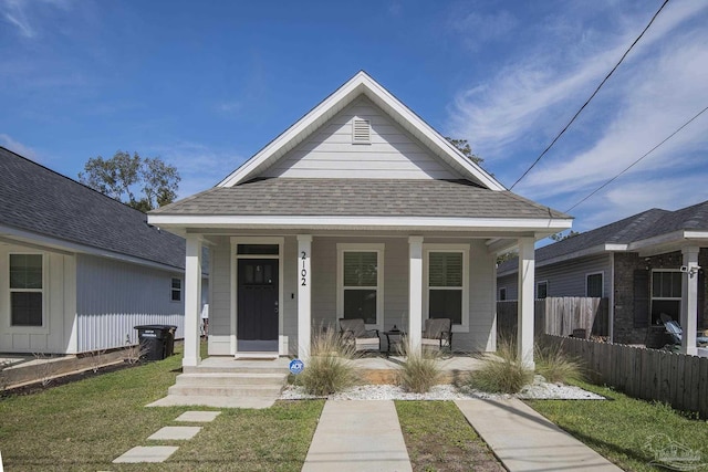 bungalow-style home with covered porch and a front lawn