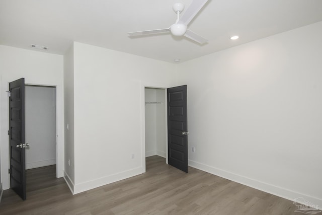 unfurnished bedroom featuring hardwood / wood-style floors, a closet, and ceiling fan