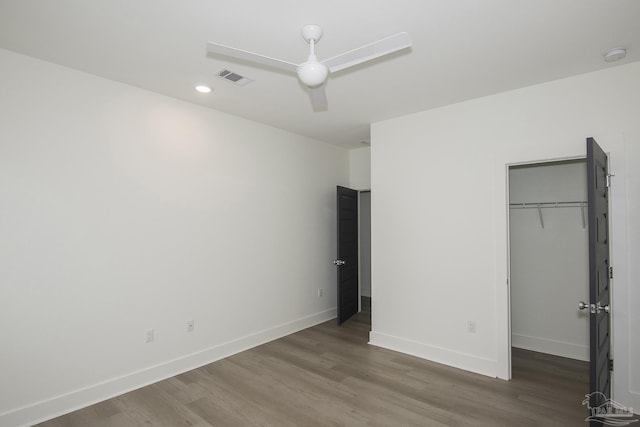 unfurnished bedroom featuring a closet, ceiling fan, and dark wood-type flooring