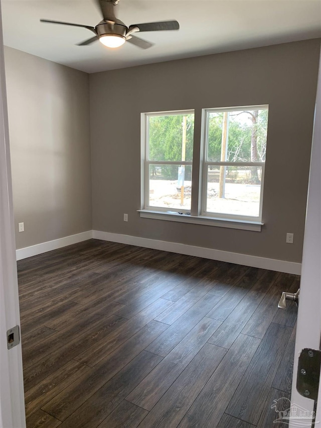 unfurnished room with dark wood-style floors, baseboards, and a ceiling fan