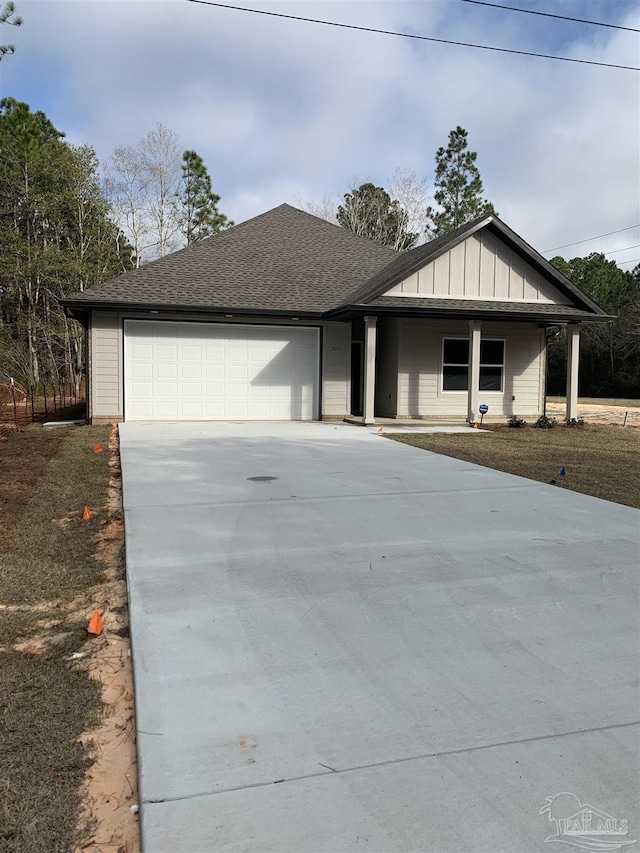 view of front of home with driveway, a shingled roof, a garage, and board and batten siding