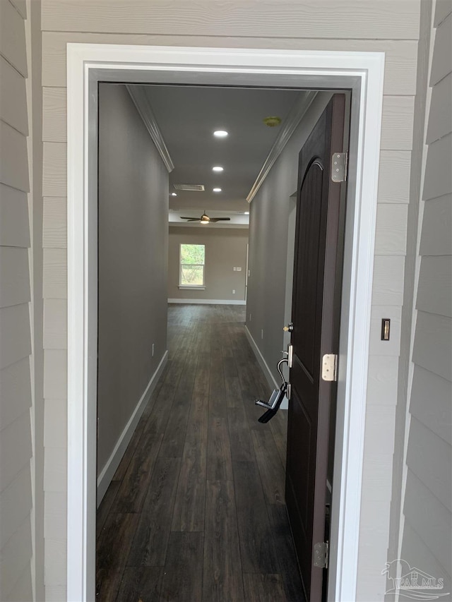 corridor with dark wood-style floors, recessed lighting, baseboards, and ornamental molding