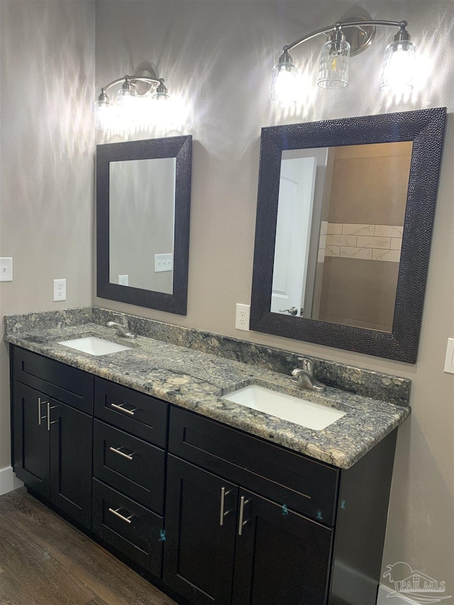 bathroom featuring double vanity, a sink, and wood finished floors