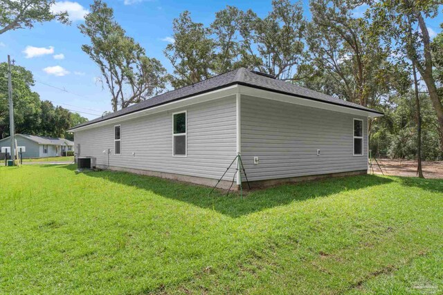 view of property exterior with central air condition unit and a lawn