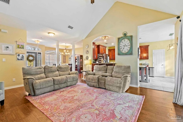 living room featuring dark hardwood / wood-style flooring, high vaulted ceiling, and a chandelier