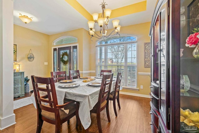 dining area with wood-type flooring and a notable chandelier