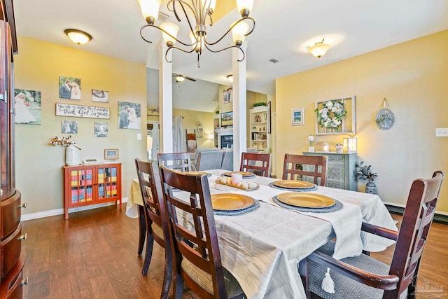 dining room with dark hardwood / wood-style flooring and ceiling fan with notable chandelier