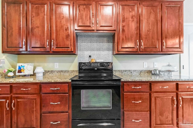 kitchen featuring black range with electric stovetop and light stone counters