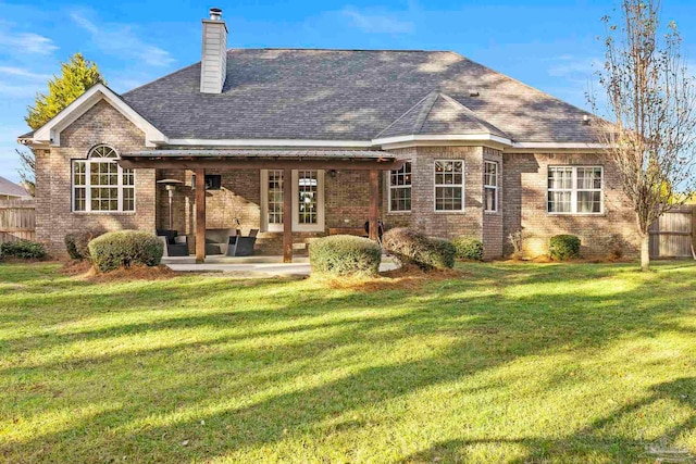 rear view of house featuring a patio area and a yard