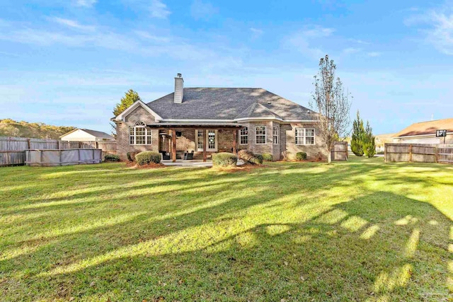 rear view of property with a yard and a patio area