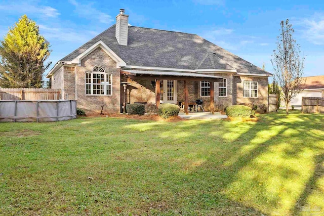 back of property with a patio area and a lawn