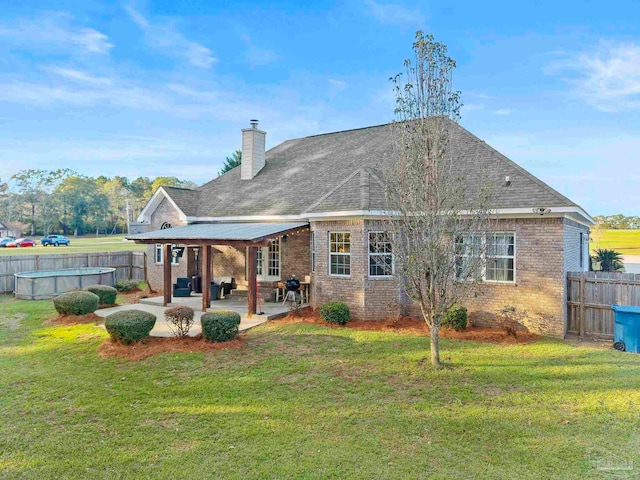 back of house featuring a yard, a patio, a fenced in pool, and an outdoor hangout area