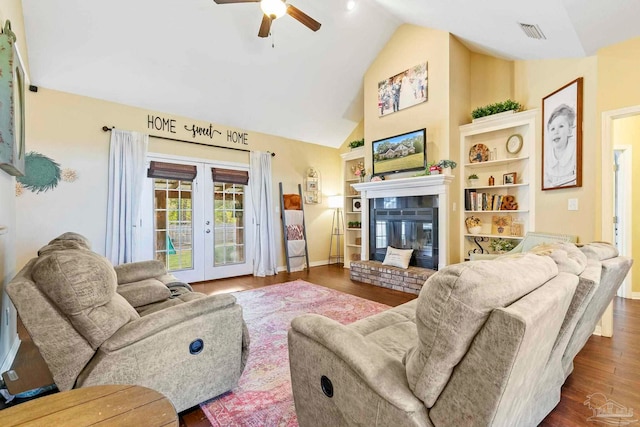 living room featuring lofted ceiling, dark wood-type flooring, french doors, ceiling fan, and a fireplace