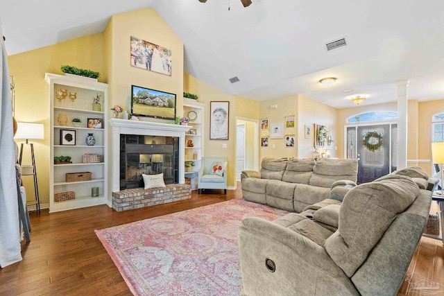 living room with dark hardwood / wood-style floors, ceiling fan, lofted ceiling, and a brick fireplace