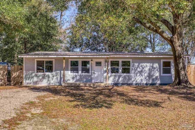 ranch-style house featuring fence