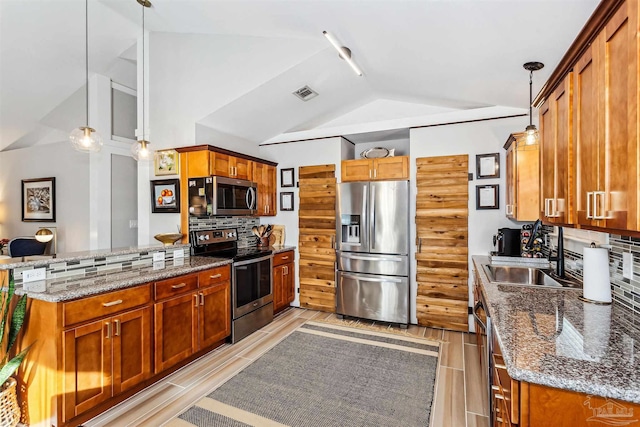 kitchen with appliances with stainless steel finishes, lofted ceiling, tasteful backsplash, sink, and hanging light fixtures