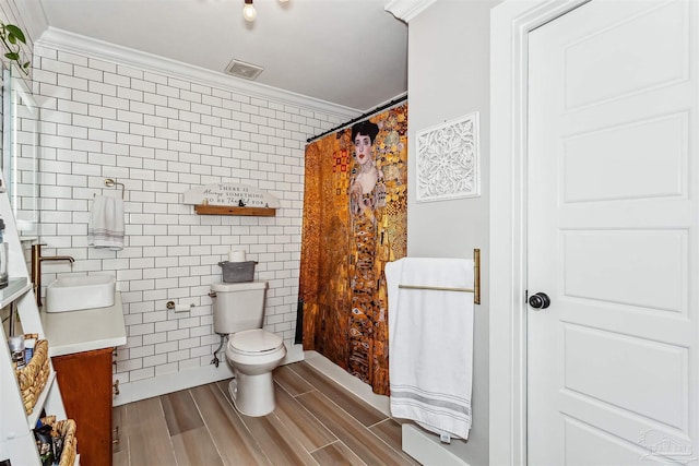 bathroom with toilet, vanity, tile walls, wood-type flooring, and ornamental molding