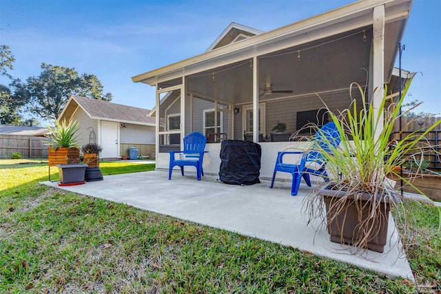 back of house featuring ceiling fan, a patio area, a sunroom, and a lawn