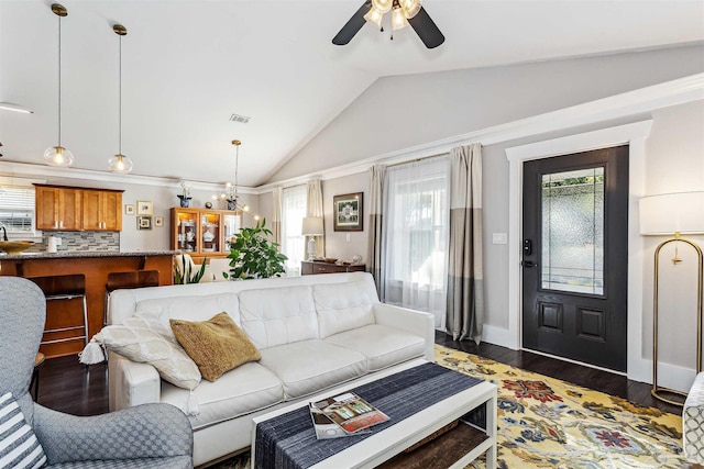 living room with vaulted ceiling, dark hardwood / wood-style flooring, and ceiling fan with notable chandelier