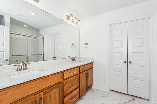 full bathroom featuring marble finish floor, a sink, visible vents, and double vanity