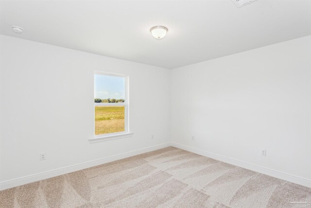 carpeted spare room featuring baseboards