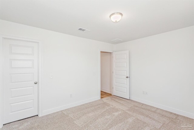 carpeted spare room with baseboards and visible vents