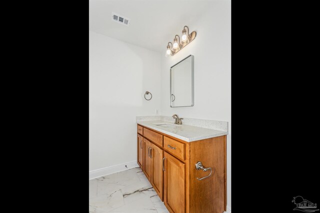 bathroom with baseboards, vanity, visible vents, and marble finish floor