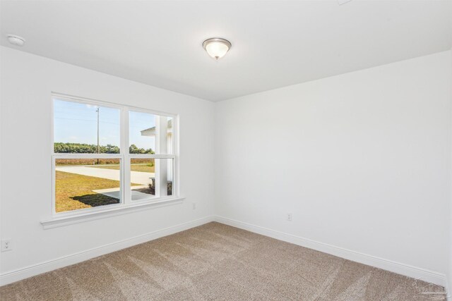 carpeted empty room with baseboards