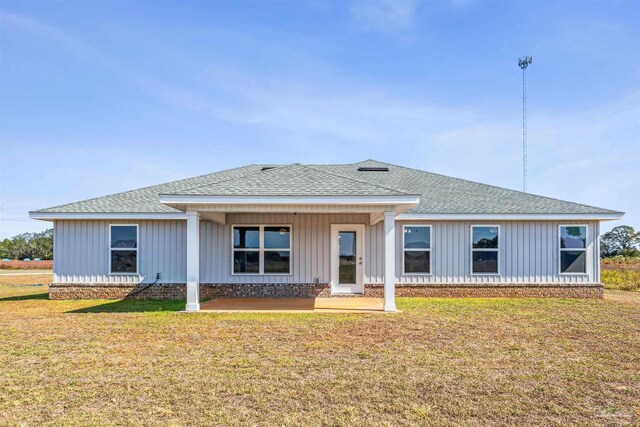 9319 Salter Rd, Pace, FL 32571 - view of front of property featuring board and batten siding, a patio area, roof with shingles, and a front lawn