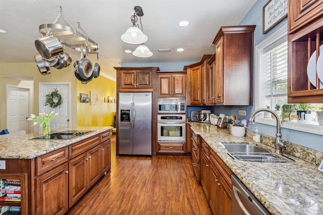 kitchen featuring pendant lighting, sink, stainless steel appliances, light stone countertops, and dark hardwood / wood-style flooring