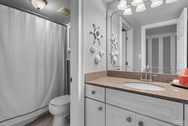 bathroom featuring tile patterned flooring, vanity, and toilet