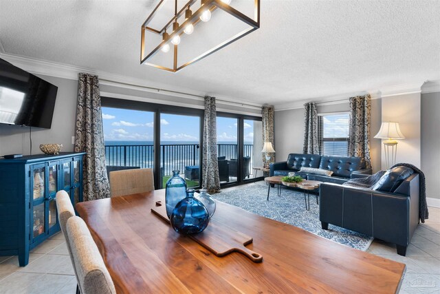 dining room with light tile patterned flooring, a water view, and crown molding