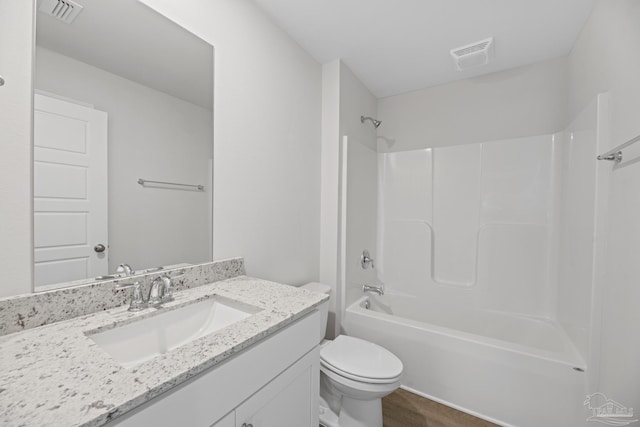 full bathroom with vanity, wood-type flooring, tub / shower combination, and toilet