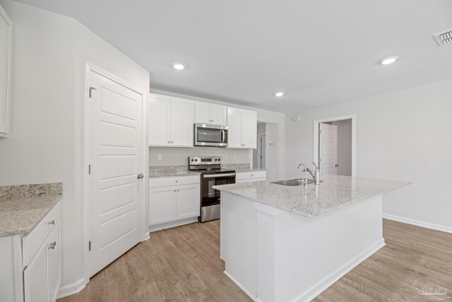 kitchen with light wood-type flooring, stainless steel appliances, white cabinetry, and sink