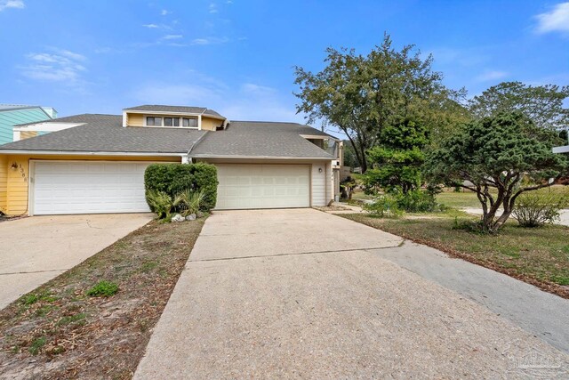 view of front facade featuring a garage, concrete driveway, and roof with shingles