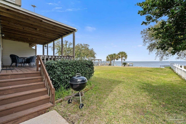 view of yard with a deck with water view and fence