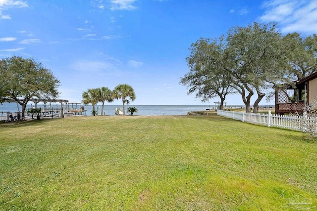 view of yard featuring a water view and fence