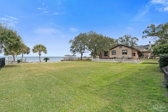 view of yard with a water view and fence