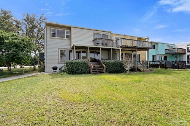 back of house featuring a lawn and a wooden deck