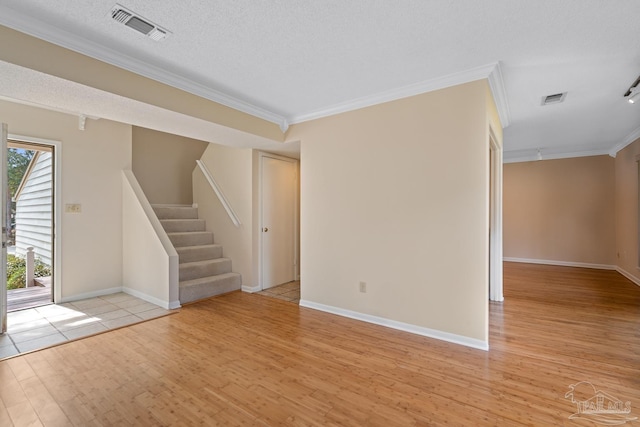 unfurnished room featuring visible vents, crown molding, stairway, and light wood finished floors