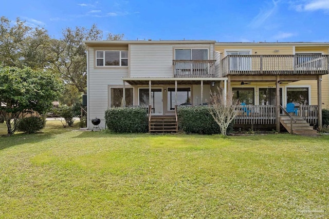 rear view of property with a balcony, a ceiling fan, and a lawn