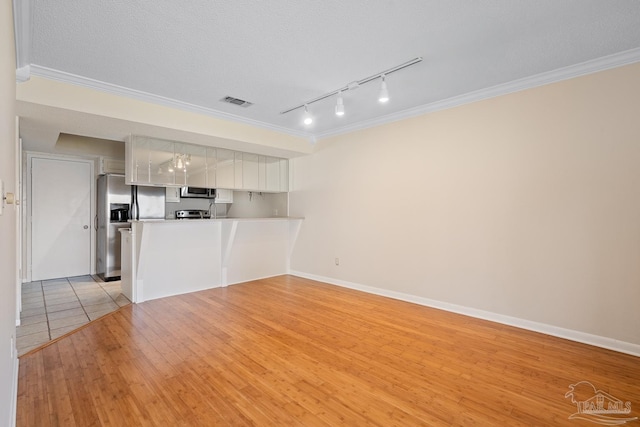 unfurnished living room featuring a textured ceiling, visible vents, baseboards, ornamental molding, and light wood-type flooring