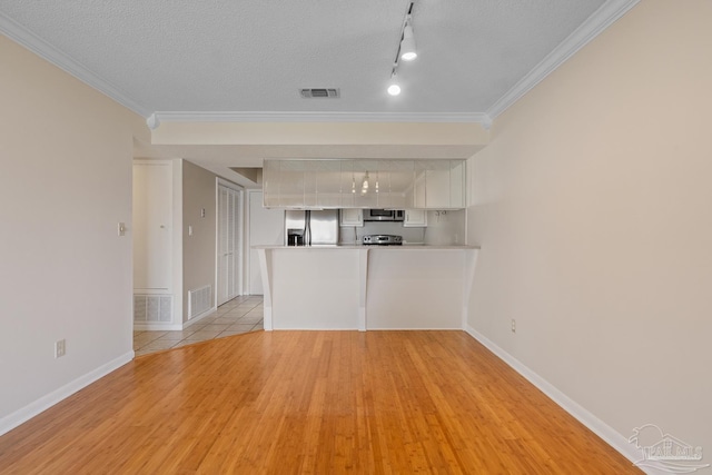 unfurnished living room featuring light wood finished floors, crown molding, visible vents, and a textured ceiling