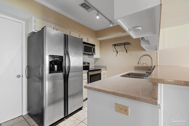 kitchen with light tile patterned floors, visible vents, light stone countertops, stainless steel appliances, and a sink