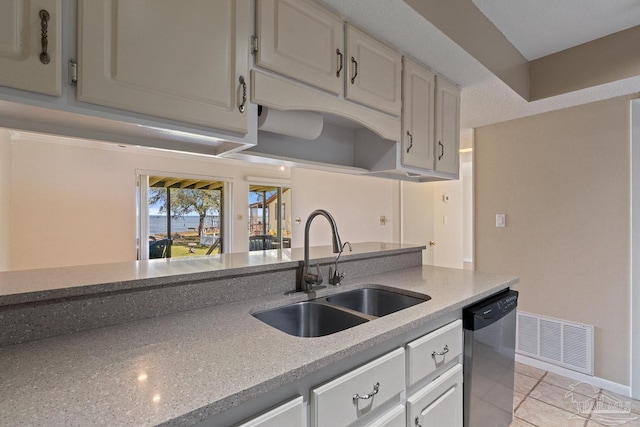 kitchen featuring light tile patterned flooring, a sink, visible vents, light countertops, and stainless steel dishwasher