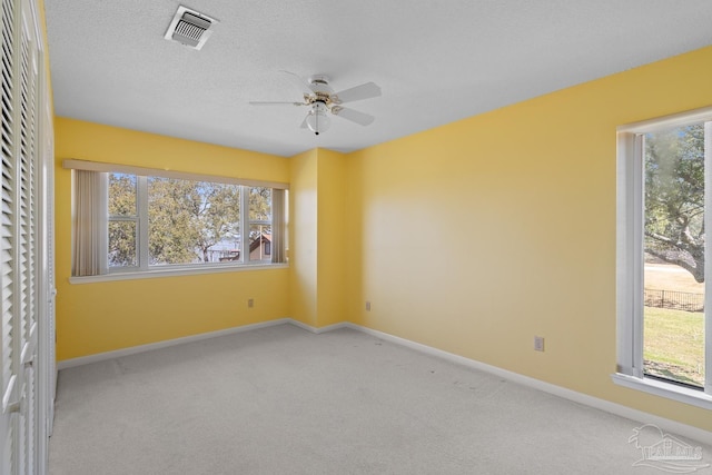 unfurnished room with baseboards, visible vents, ceiling fan, a textured ceiling, and carpet flooring