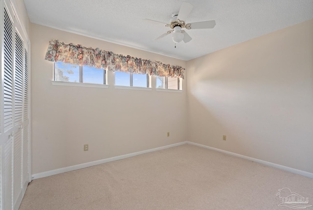 unfurnished bedroom featuring carpet floors, a textured ceiling, baseboards, and a closet